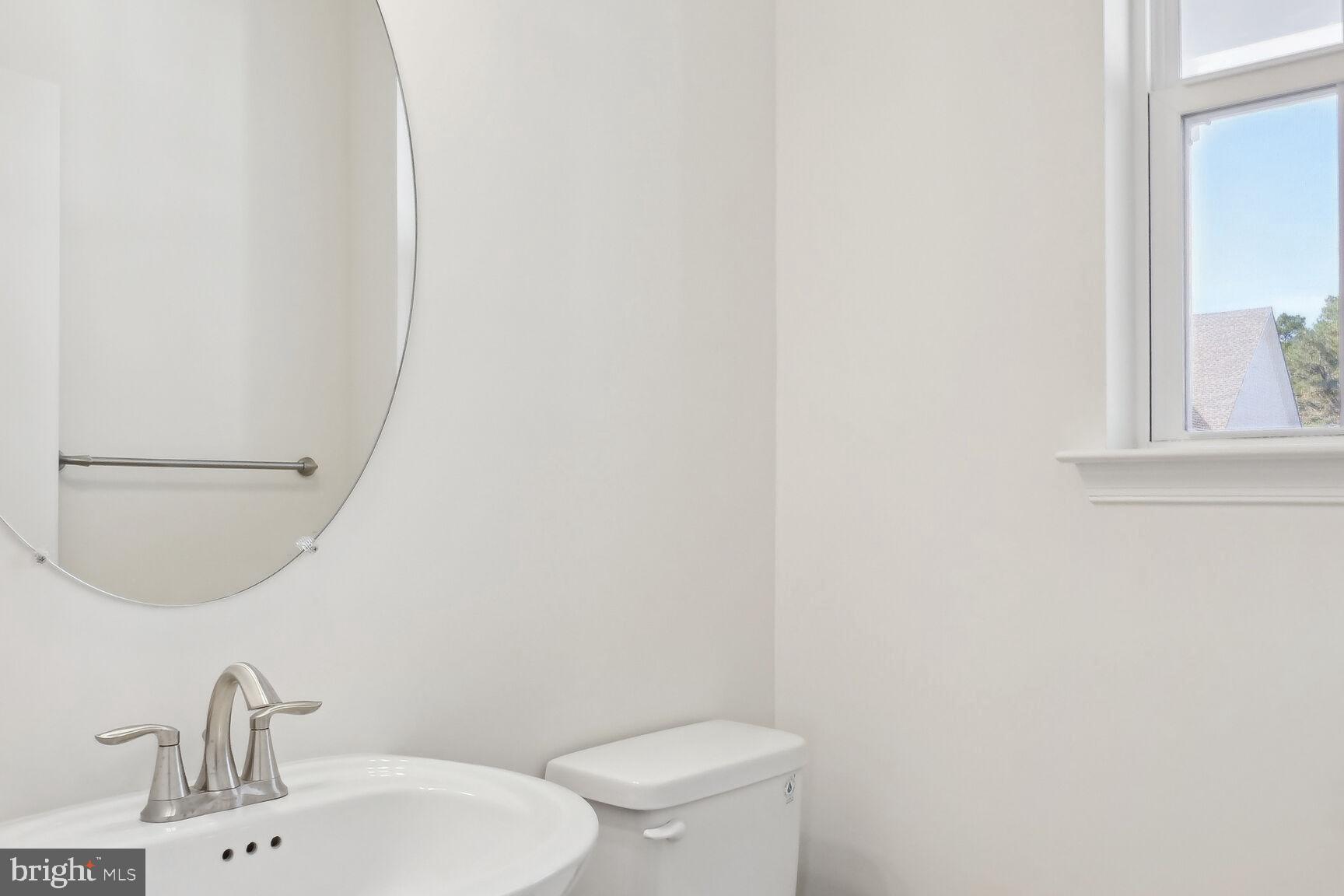 25017 Cypress Court Lewes, DE 19958 - Photo 8 of 14 a bathroom with a sink a toilet and mirror
