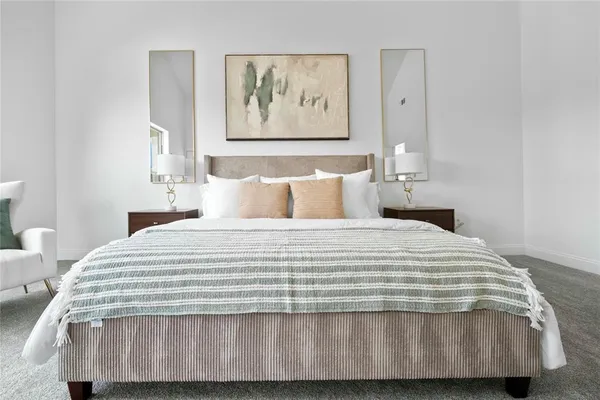 a bedroom with a bed and painting on the wall