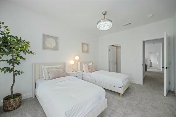 a bedroom with two beds and a potted plant