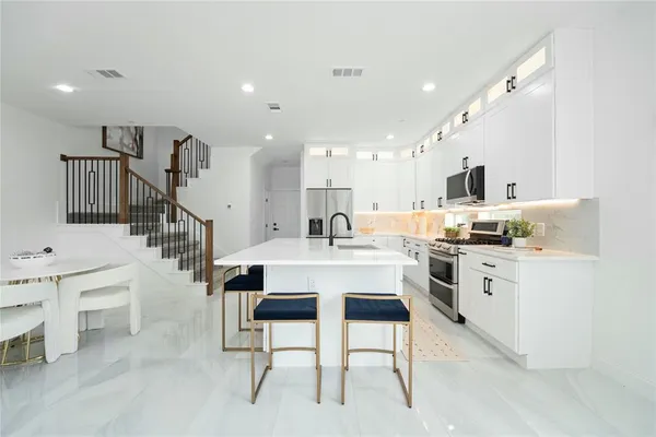 a kitchen with appliances a sink and cabinets