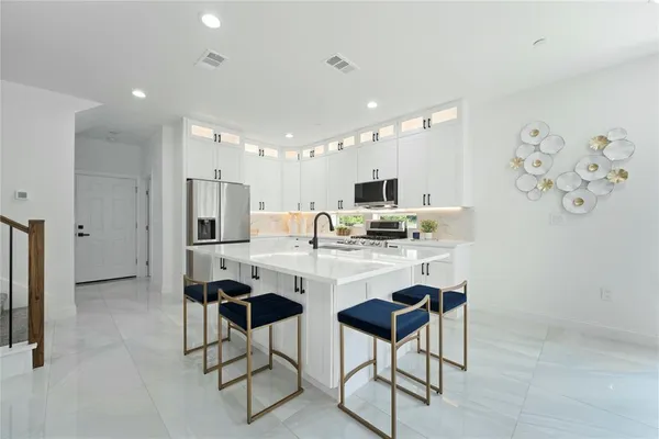 a kitchen with stainless steel appliances kitchen island granite countertop a refrigerator and a stove top oven