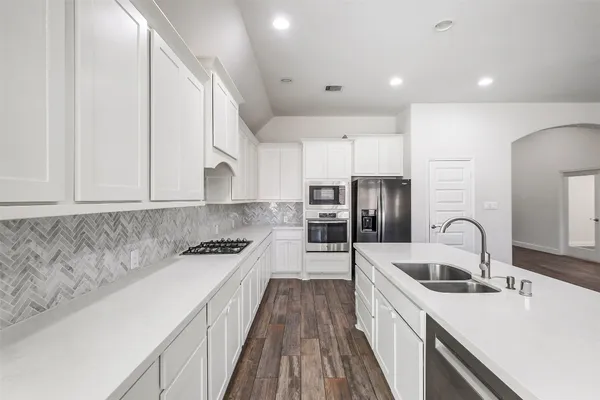 a kitchen with stainless steel appliances granite countertop a sink stove and refrigerator