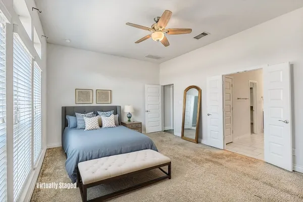 a bedroom with a large bed couch and a window