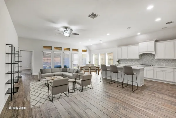 a living room with furniture and a wooden floor