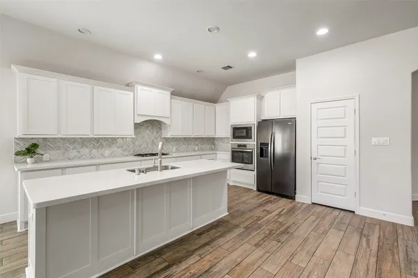 a kitchen with stainless steel appliances granite countertop a sink stove and refrigerator