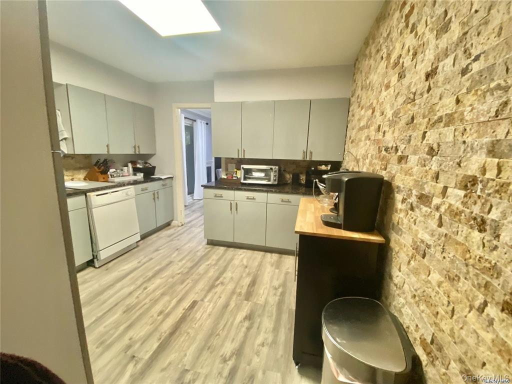 107 Baker Hill Road Great Neck, NY 11023 - Photo 11 of 33 Eat-in-Kitchen with gray cabinetry, white dishwasher, light wood-type flooring, butcher block countertops