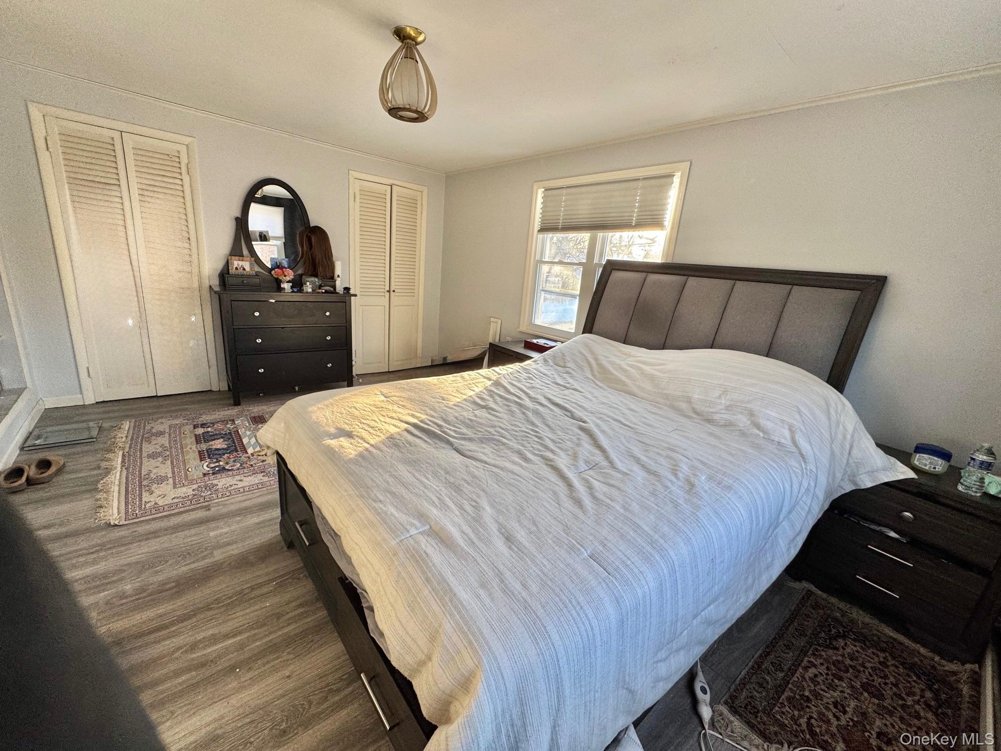 107 Baker Hill Road Great Neck, NY 11023 - Photo 19 of 29 a bedroom with a bed and a dresser