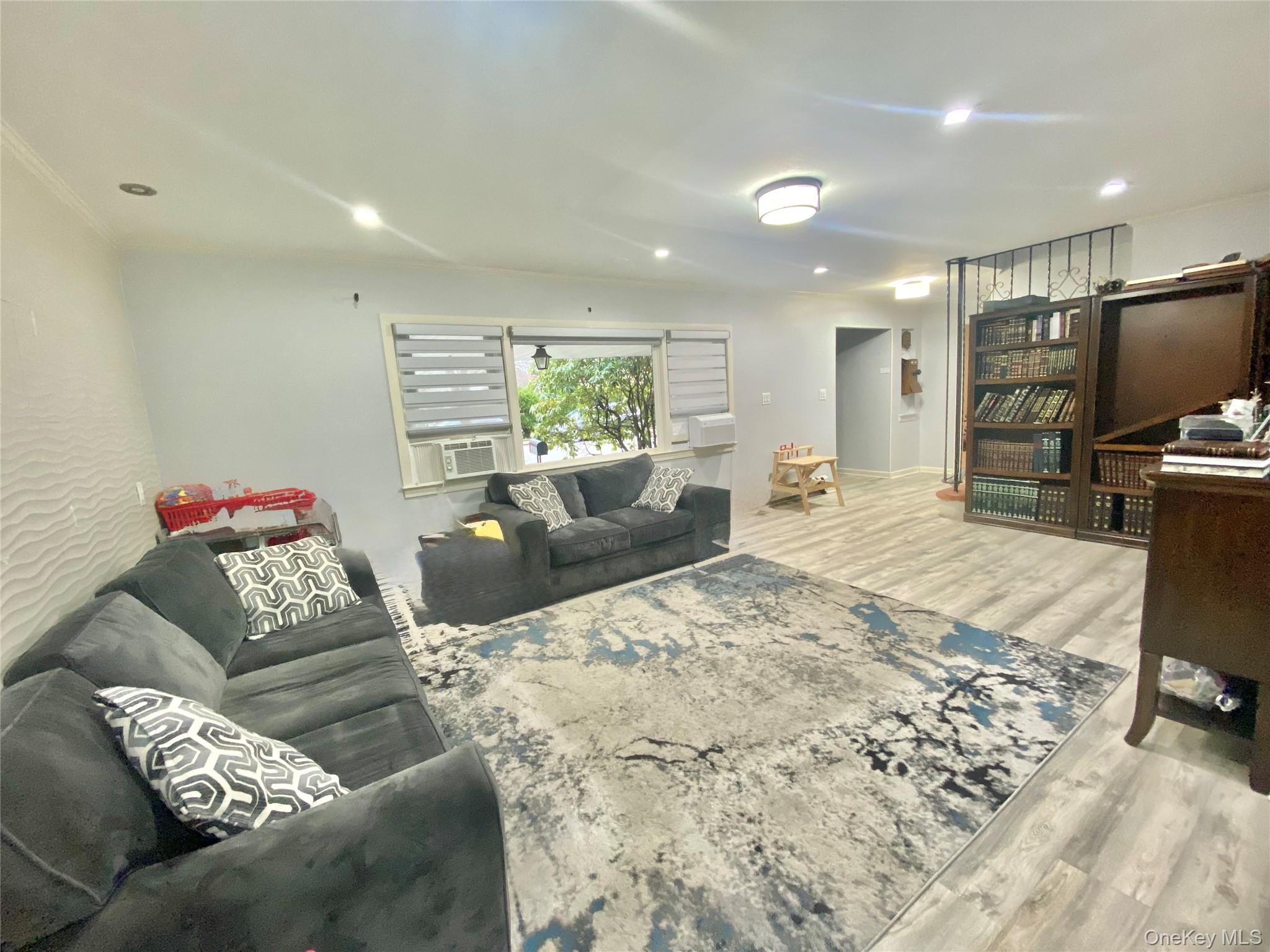 107 Baker Hill Road Great Neck, NY 11023 - Photo 2 of 29 a living room with furniture and a flat screen tv
