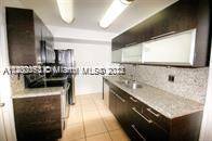 13936 Southwest 46th Terrace, Unit B Miami, FL 33175 - Photo 3 of 11 a kitchen with stainless steel appliances granite countertop a sink a stove and a refrigerator
