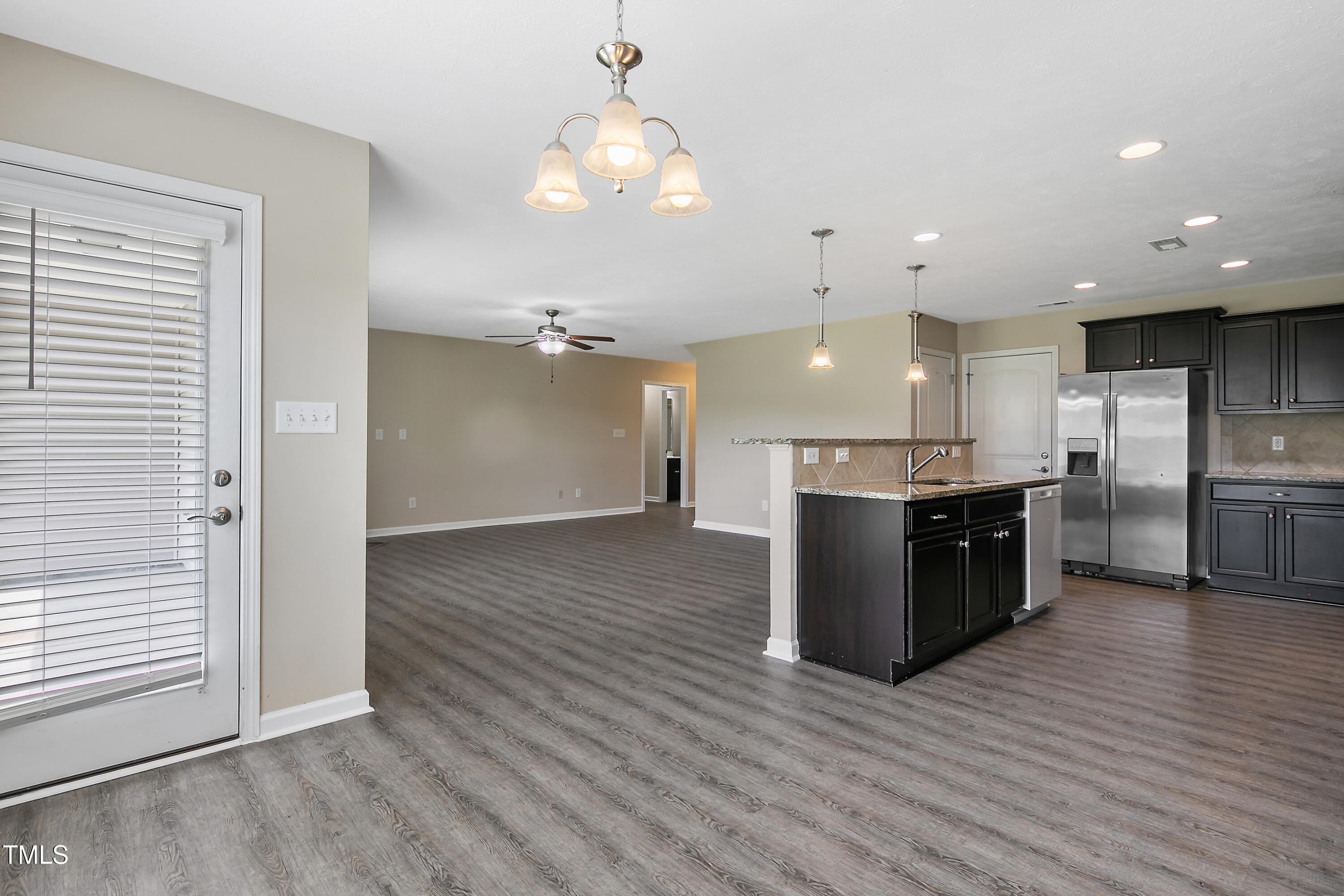 949 Raspberry Road Stedman, NC 28391 - Photo 12 of 31 a large kitchen with a large center island in wooden cabinets and stainless steel appliances