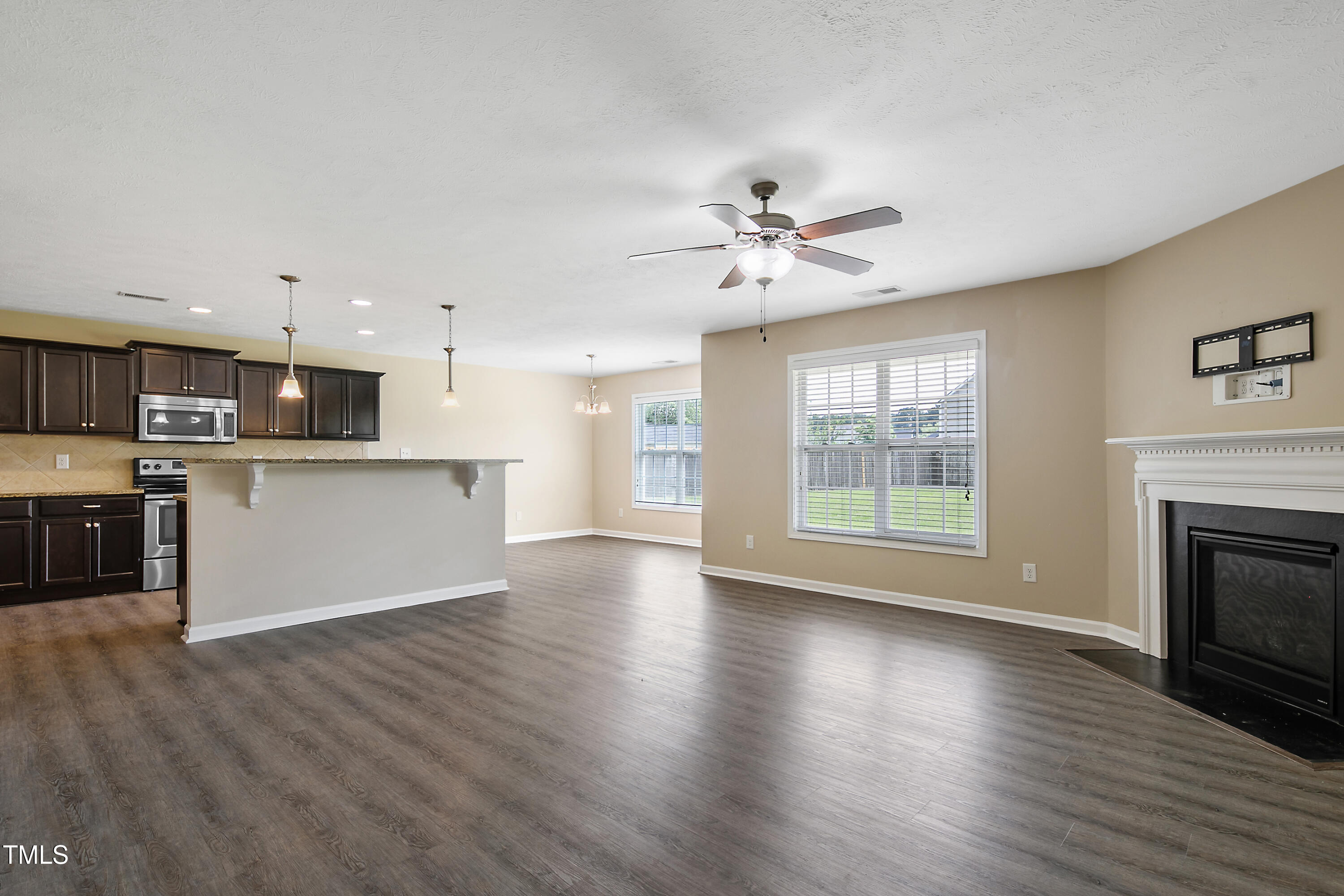 949 Raspberry Road Stedman, NC 28391 - Photo 4 of 31 a view of an empty room with wooden floor and a kitchen