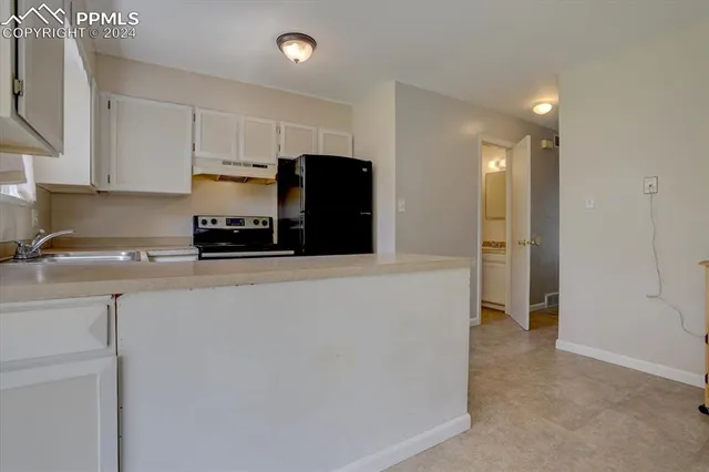 a kitchen with refrigerator and cabinets