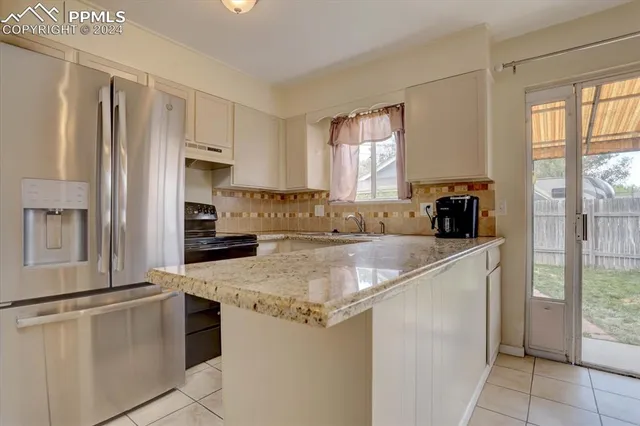 a kitchen with a refrigerator a stove a sink and a window