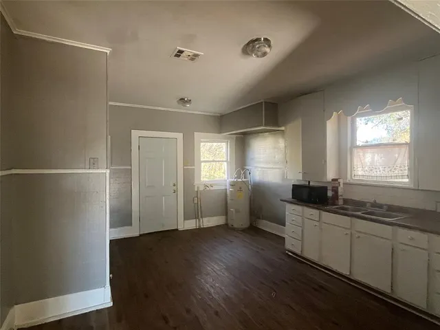 a kitchen with a sink and wooden floor