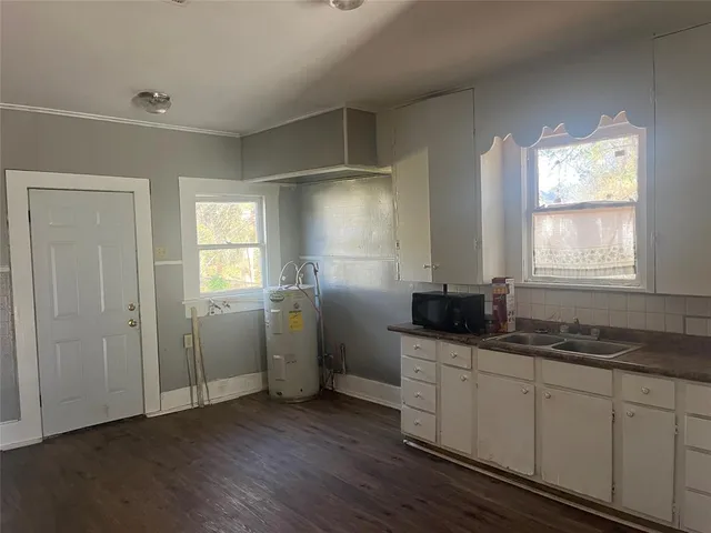 a kitchen with granite countertop a sink and cabinets