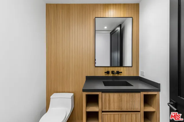a bathroom with a sink a toilet and mirror