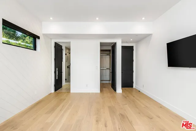 a view of a livingroom with wooden floor and a flat screen tv