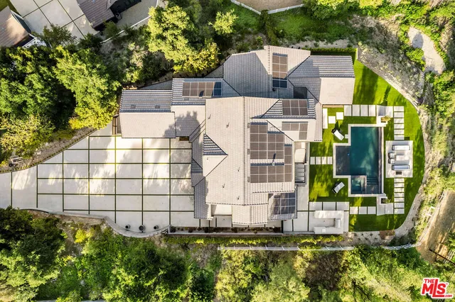 a view of a big house with a big yard and large trees