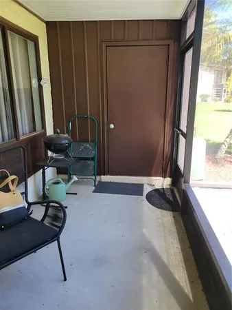 a living room with furniture a large window and a wooden door