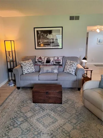 a living room with couches and painting on the wall