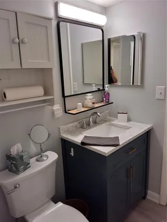 a bathroom with a toilet sink and mirror