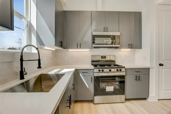a kitchen with a sink stove and wooden cabinets