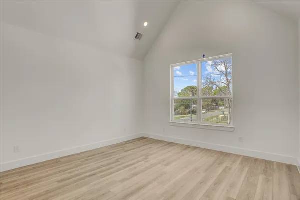 an empty room with wooden floor and window
