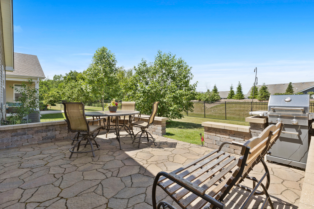 1150 Americana Avenue Pingree Grove, IL 60140 - Photo 21 of 30 a view of a patio with table and chairs and potted plants with wooden fence