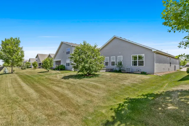a front view of house with yard and trees in the background