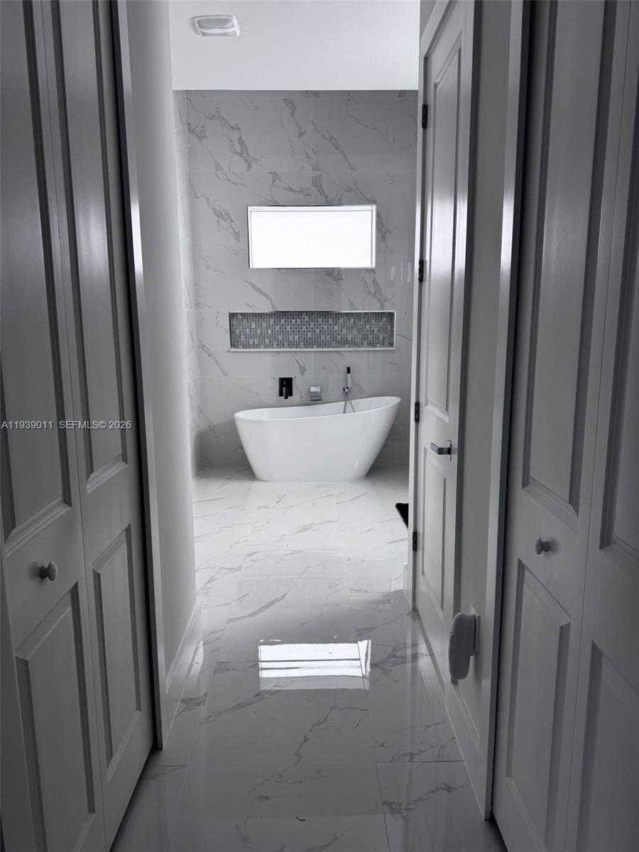 11 Connecticut Road Lehigh Acres, FL 33936 - Photo 5 of 11 a bathroom with a bathtub and a shower