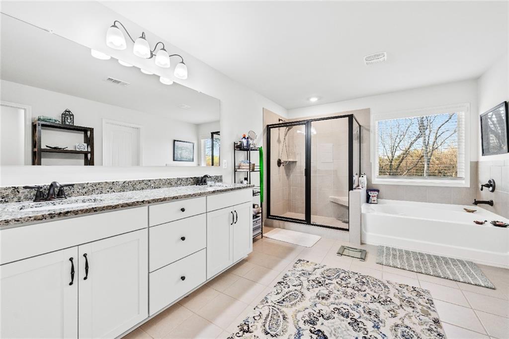 7545 Rambling Vale Dawsonville, GA 30534 - Photo 30 of 46 a spacious bathroom with a granite countertop sink mirror and bathtub