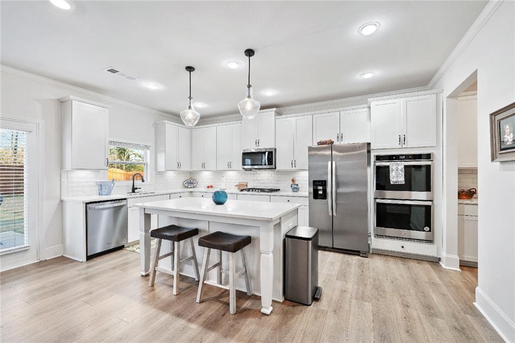 7545 Rambling Vale Dawsonville, GA 30534 - Photo 9 of 46 a kitchen with stainless steel appliances a stove a sink island and a refrigerator