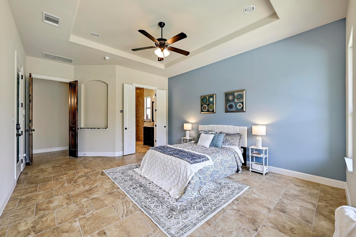 221 Tower Road Georgetown, TX 78628 - Photo 17 of 40 a spacious bedroom with a large bed and a chandelier