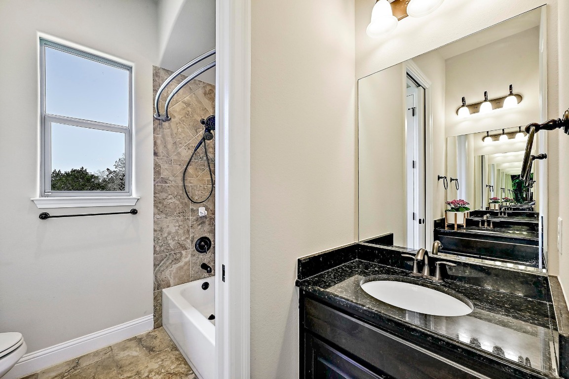 221 Tower Road Georgetown, TX 78628 - Photo 22 of 40 a bathroom with a granite countertop sink and a mirror a bathtub