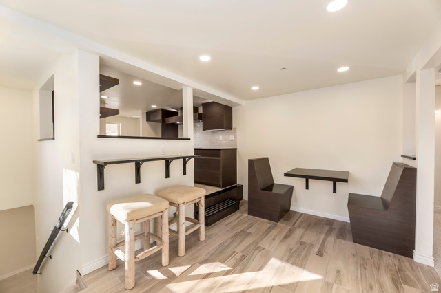 4658 Box Elder Street Salt Lake City, UT 84107 - Photo 10 of 17 Open-concept lower level featuring wood-finish flooring, recessed lighting, and a built-in breakfast bar with shelving