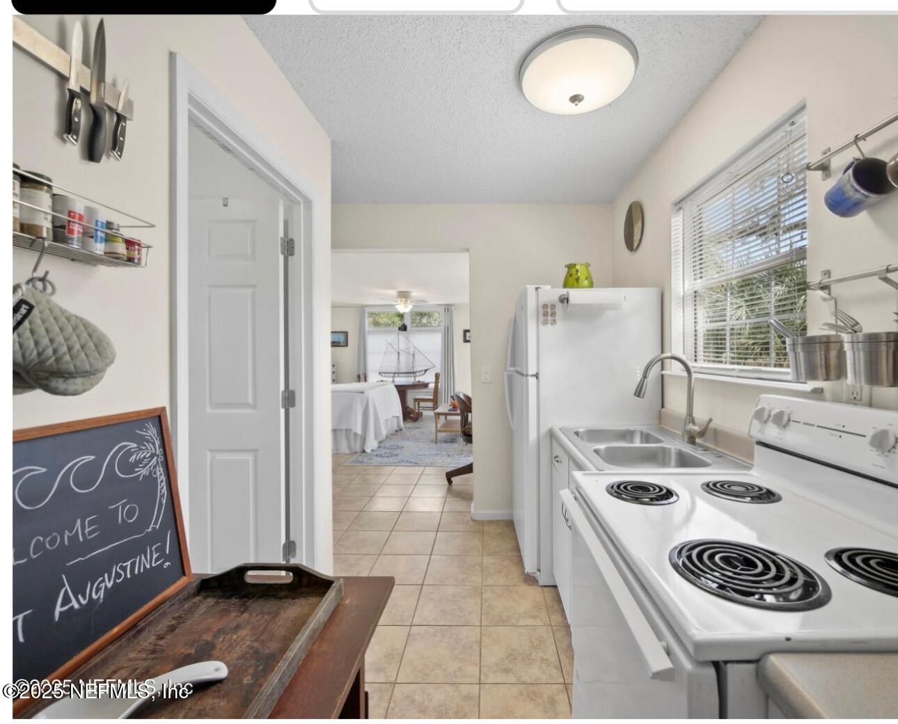 509 Live Oak Street, Unit 1 St. Augustine, FL 32084 - Photo 7 of 9 a kitchen with a refrigerator a stove a sink and a stove with wooden floor