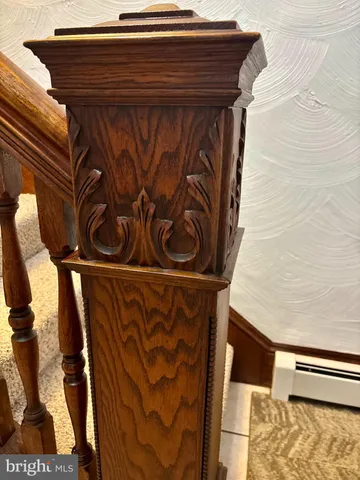 a view of an empty room with wooden floor and stairs