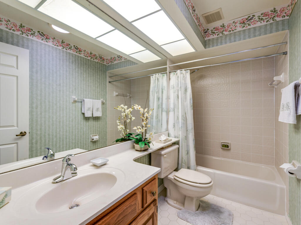 602 Augusta Boulevard, Unit 3 Naples, FL 34113 - Photo 8 of 8 a bathroom with a sink a toilet a mirror and shower