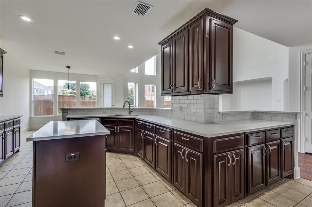 1721 Brookside Drive Prosper, TX 75078 - Photo 4 of 12 a kitchen with kitchen island granite countertop a sink counter top space and cabinets