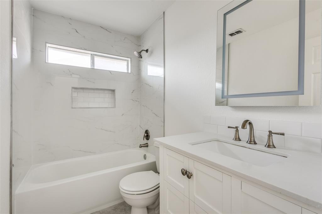 1721 Brookside Drive Prosper, TX 75078 - Photo 9 of 12 a bathroom with a toilet a sink a mirror a bathtub and shower