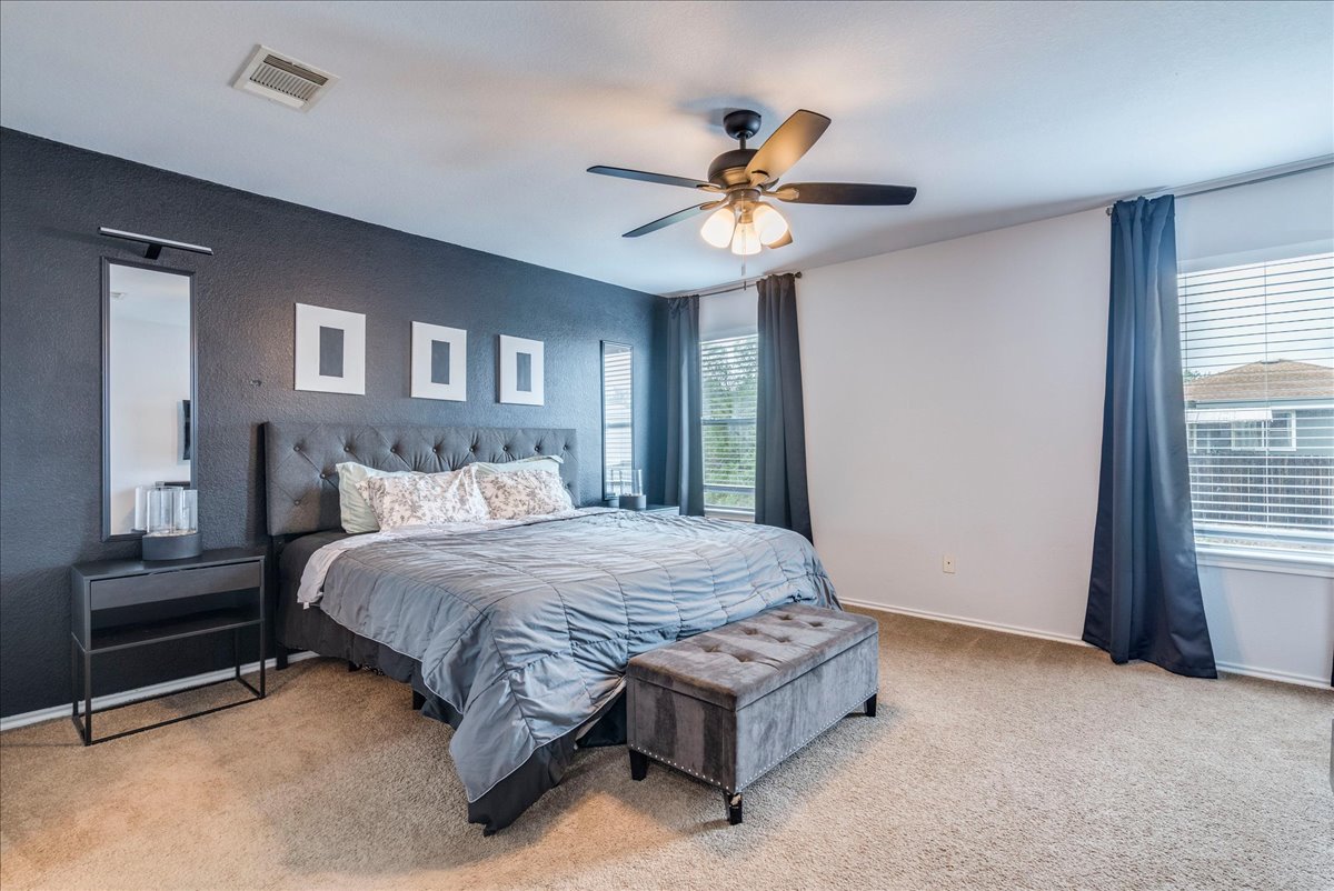 148 Buttercup Way Kyle, TX 78640 - Photo 14 of 30 a bedroom with a bed and a chandelier