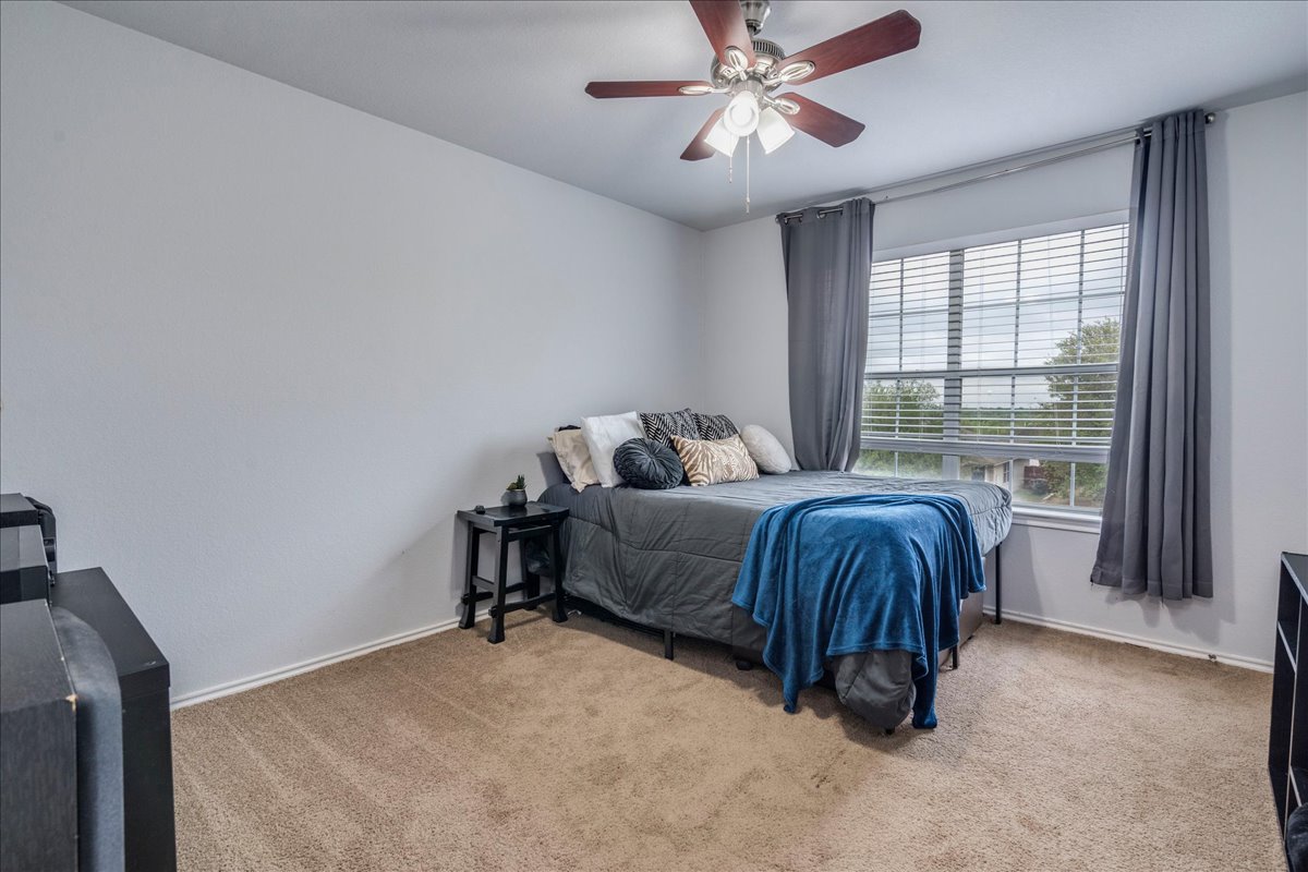 148 Buttercup Way Kyle, TX 78640 - Photo 19 of 30 a bedroom with a bed and a window
