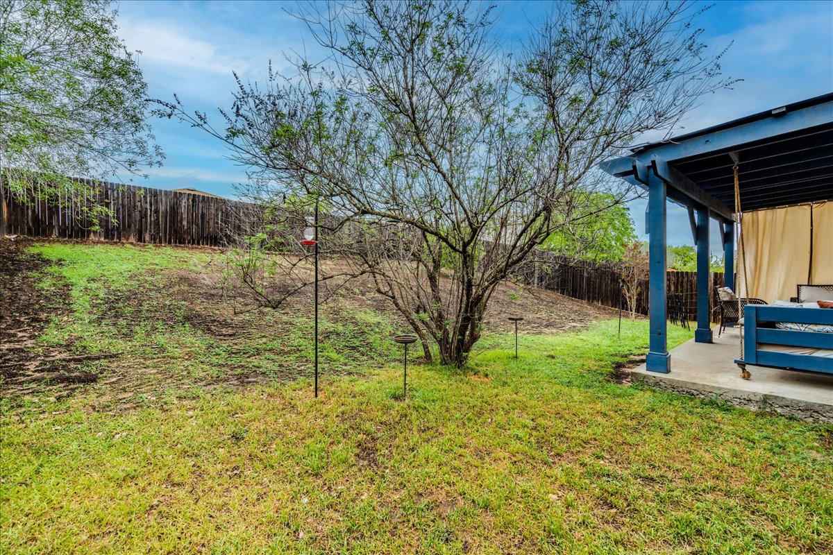 148 Buttercup Way Kyle, TX 78640 - Photo 29 of 30 a view of backyard with table and chairs and wooden fence