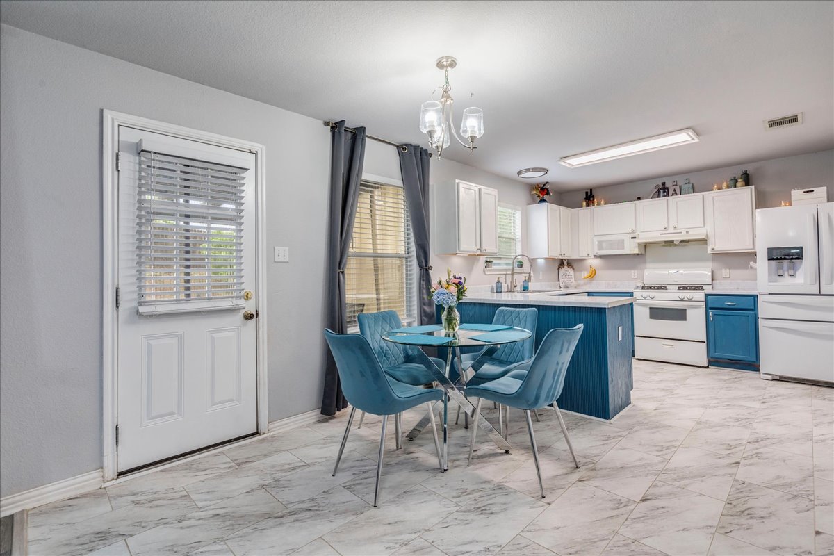 148 Buttercup Way Kyle, TX 78640 - Photo 9 of 30 a kitchen with kitchen island a dining table and chairs