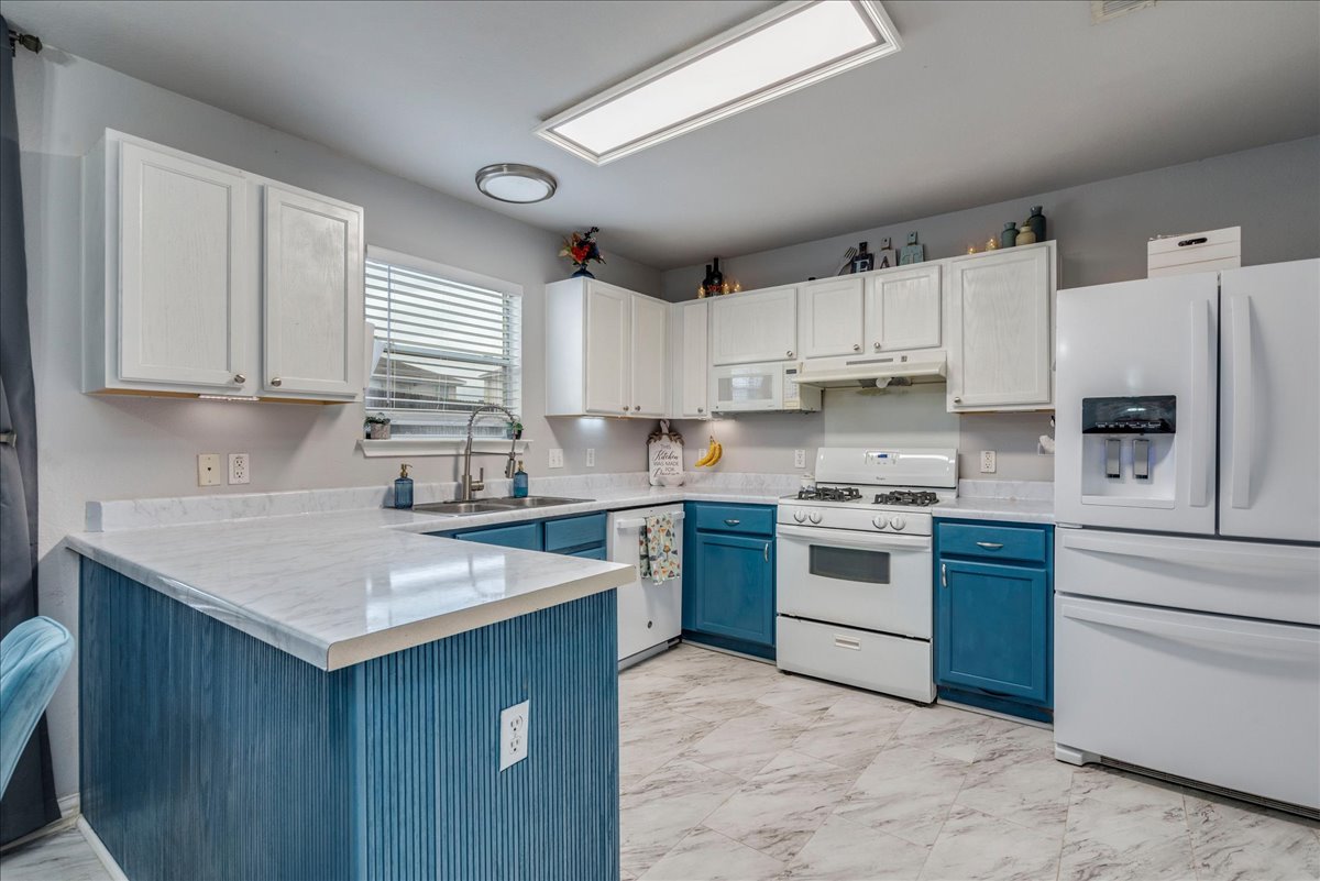 148 Buttercup Way Kyle, TX 78640 - Photo 10 of 30 a kitchen with kitchen island granite countertop a sink stainless steel appliances and white cabinets