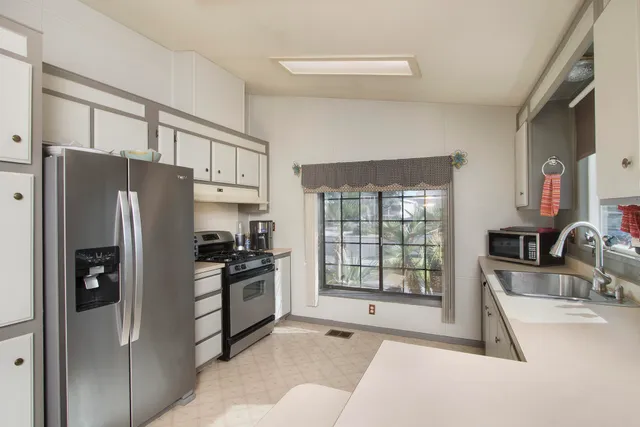 a kitchen with stainless steel appliances a stove a refrigerator and cabinets