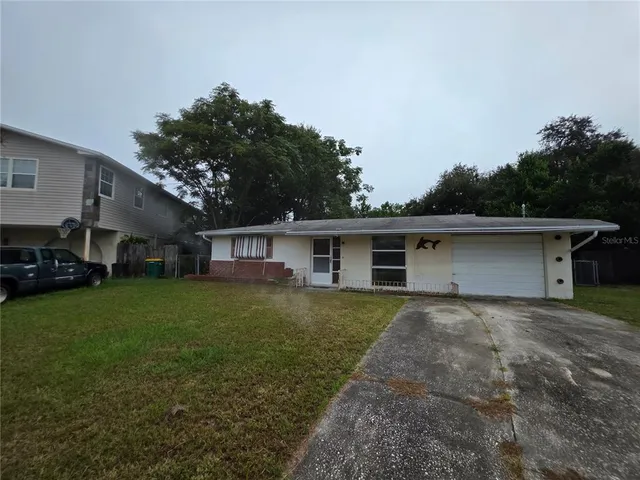 a front view of a house with a garden and trees