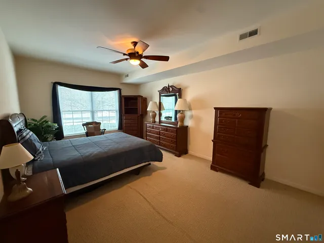 a bed room with a bed and a ceiling fan