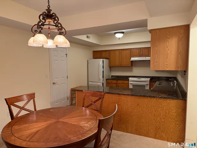 a kitchen with stainless steel appliances granite countertop a sink a microwave a refrigerator and a stove
