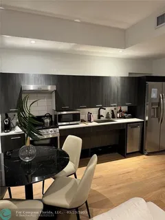 a kitchen with a table chairs a stove and a refrigerator